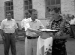На знімку: М. В. Кінаш вручає хліб-сіль одному з кращих комбайнерів господарства Максиму Петровичу Теплицькому. Щасливого ужинку, хлібороби