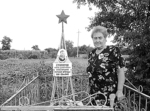 На знімку: Надія Никифорівна Карман на городі, біля могили старшини морської бригади Карпа Столярова. У саду спочиває старшина Столяров